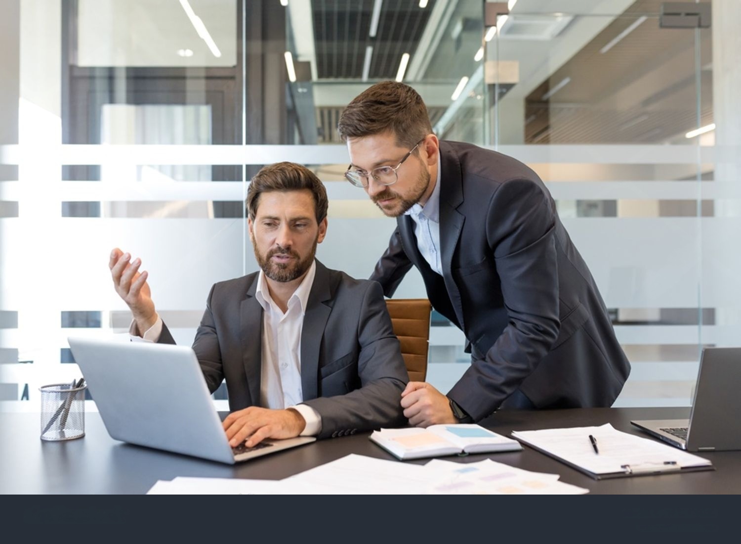 Trois professionnels souriants dans un bureau moderne.