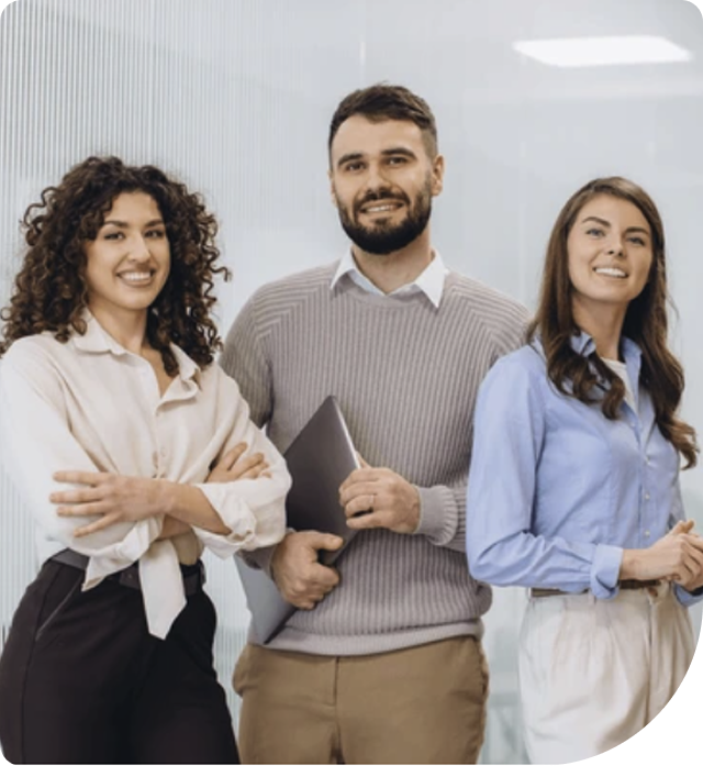 Three smiling professionals in a modern office.
